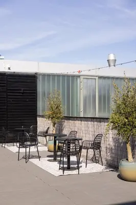 a patio with tables and chairs and a fence at Hotel2Stay in Amsterdam