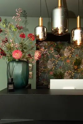 a vase with flowers on a table with lights at Hotel2Stay in Amsterdam