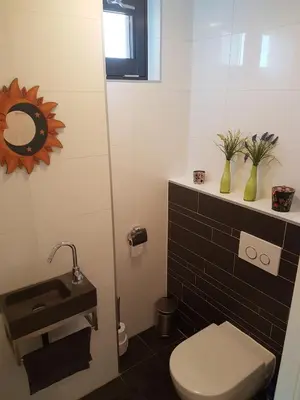 a bathroom with a toilet and a sink at Casa Mirador Sleep Inn in Almere