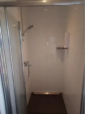 a shower with a glass door in a bathroom at Casa Mirador Sleep Inn in Almere