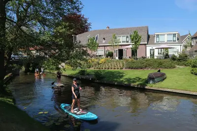 a group of people on paddle boards in a river at B&B - Pension Het Oude Dorp in Katwijk