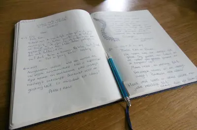 an open notebook with a pen on a table at B&B - Pension Het Oude Dorp in Katwijk