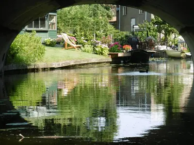 a bridge over a river with a boat in it at B&B - Pension Het Oude Dorp in Katwijk