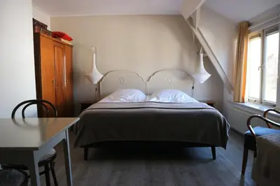 a bedroom with a bed and a table and a table sidx sidx sidx at B&B - Pension Het Oude Dorp in Katwijk