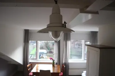 a large light hanging over a dining room table at B&B - Pension Het Oude Dorp in Katwijk