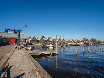 a marina with boats in the water and houses at House by Uitgeestermeer with Garden in Uitgeest