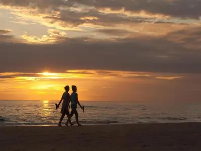 a couple walking on the beach at sunset at Holiday Home in Noordwijk near Beach in Noordwijk