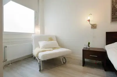 a white chair sitting in a bedroom with a window at H 58 in Amsterdam