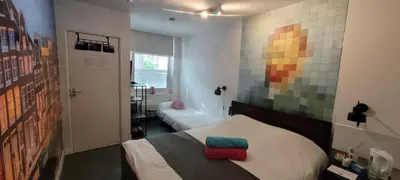 a room with two beds and a painting on the wall at H 58 in Amsterdam