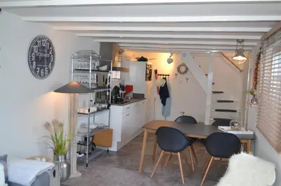 a kitchen and dining room with a table and chairs at Ferienhaus Glücklich am Meer 1 mit Wellnesszugang in Egmond aan Zee