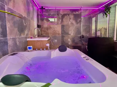 a bathroom with a large tub with purple lighting at Ferienhaus Glücklich am Meer 1 mit Wellnesszugang in Egmond aan Zee