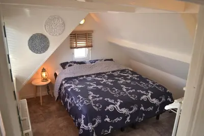 a bedroom with a bed in a attic at Ferienhaus Glücklich am Meer 1 mit Wellnesszugang in Egmond aan Zee