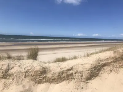 a sandy beach with the ocean in the background at Ferienhaus Glücklich am Meer 1 mit Wellnesszugang in Egmond aan Zee