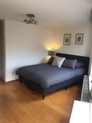 a bedroom with a large bed with a blue bedspread at Bridge Inn in Amsterdam