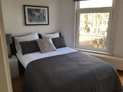 a bedroom with a large bed with a window at Bridge Inn in Amsterdam