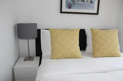 a bed with yellow and white pillows and a lamp at Bridge Inn in Amsterdam