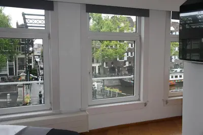 three windows in a room with a view of a city at Bridge Inn in Amsterdam