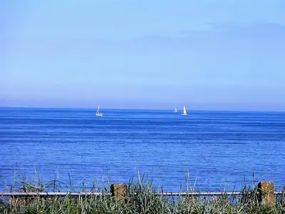 a large body of water with sailboats in the distance at Benny's Beach House 2 in Zandvoort