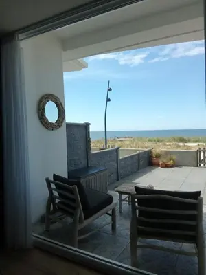 a patio with two chairs and a table and a view of the ocean at Benny's Beach House 2 in Zandvoort