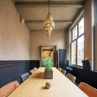 a conference room with a table and a chandelier at Grand Hotel Alkmaar in Alkmaar