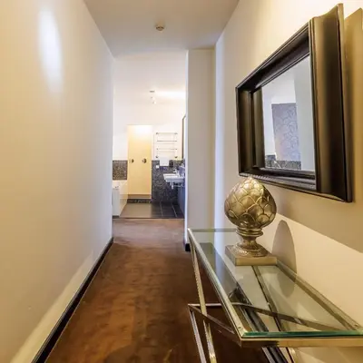 a hallway with a glass table and a mirror at Grand Hotel Alkmaar in Alkmaar