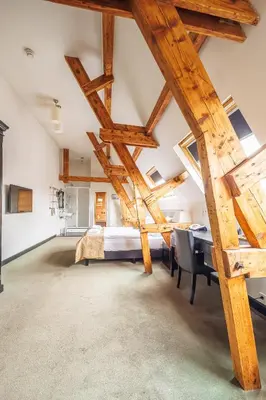 a large attic bedroom with a bed and a table at Grand Hotel Alkmaar in Alkmaar