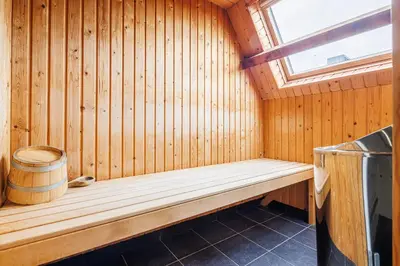 a wooden bench in a sauna with a window at Grand Hotel Alkmaar in Alkmaar