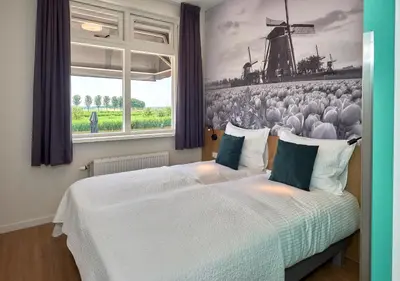 a bedroom with two beds and a window at Hotel VILLA GROET in Avenhorn