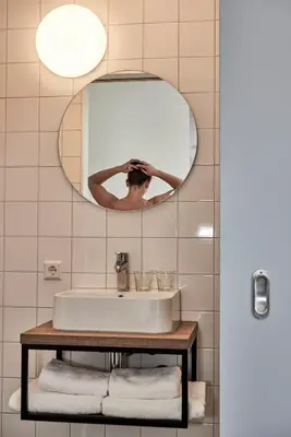 a bathroom with a sink and a mirror at Hotel VILLA GROET in Avenhorn
