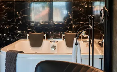 a bath tub with two chairs and a bath tub at Hotel VILLA GROET in Avenhorn