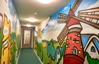 a hallway with a mural of a building at Hotel VILLA GROET in Avenhorn