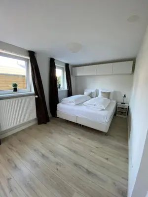 a bedroom with a white bed and a window at @Juliette in Zandvoort