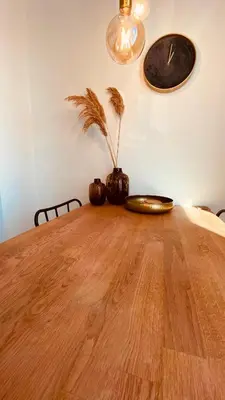 a wooden table with a clock on the wall at @Juliette in Zandvoort
