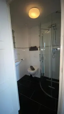 a bathroom with a toilet and a glass shower at @Juliette in Zandvoort