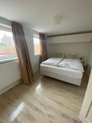 a bedroom with a white bed and a window at @Juliette in Zandvoort