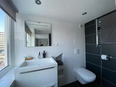 a bathroom with a sink and a toilet and a mirror at @Juliette in Zandvoort