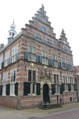 a large brick building with a clock tower on top at MY-A-Mi-Go-S in Muiderberg