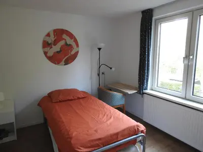 a small bedroom with a bed and a window at MY-A-Mi-Go-S in Muiderberg