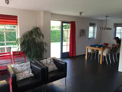 a living room with a couch and a table at Vakantiehuis Zeeduinenbos in Schoorl