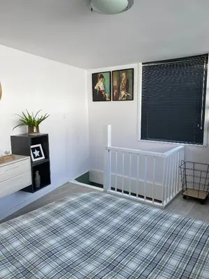 a white room with a crib and a window at Huisje 16 in Noordwijk aan Zee