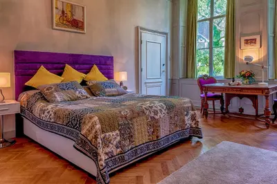 a bedroom with a large bed with a purple headboard at B&B Het Hart van Haarlem in Haarlem