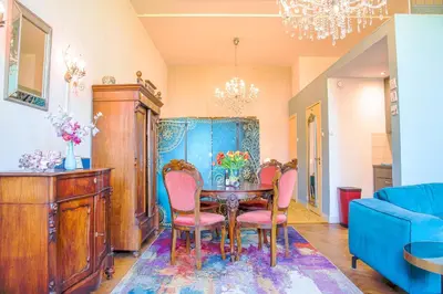 a dining room with a table and pink chairs at B&B Het Hart van Haarlem in Haarlem