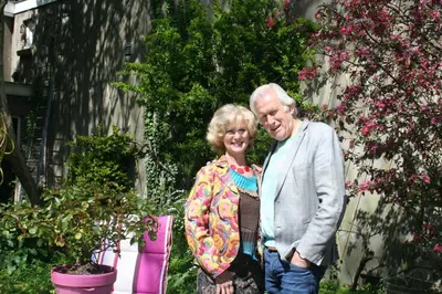 an older man and woman standing in a garden at B&B Het Hart van Haarlem in Haarlem
