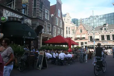 a group of people sitting at tables on a city street at B&B Het Hart van Haarlem in Haarlem