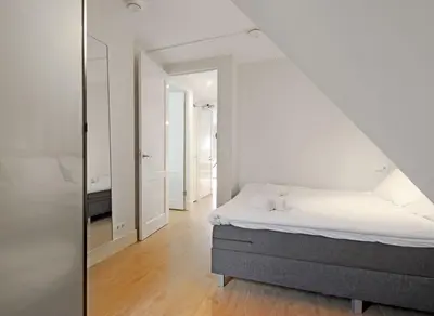 a white bedroom with a bed and a mirror at 2 bedroom loft near Rijksmuseum in Amsterdam