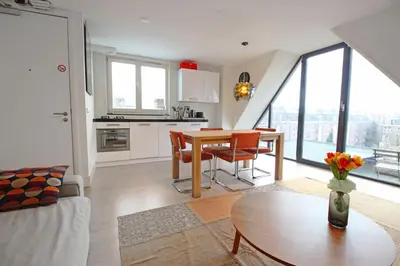 a kitchen and living room with a table and chairs at 2 bedroom loft near Rijksmuseum in Amsterdam