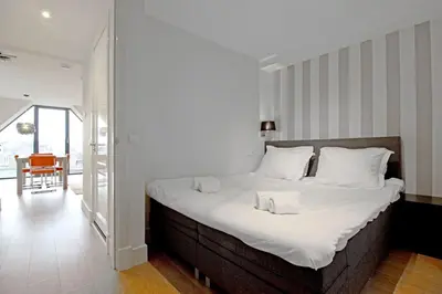 a bedroom with a large bed with white sheets at 2 bedroom loft near Rijksmuseum in Amsterdam