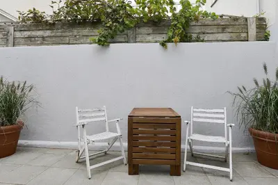 two chairs and a wooden dresser in front of a wall at Endless Summer Beach Apartments in Zandvoort