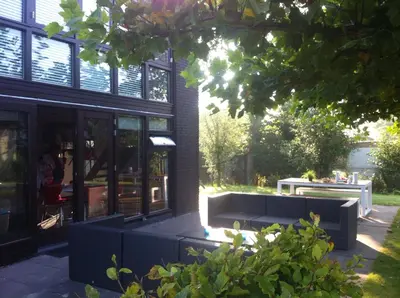 a building with a bench in front of it at Bergen Holiday Home in Schoorl