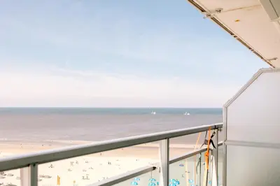 a view of the beach from the balcony of a building at Dare to be different in Zandvoort